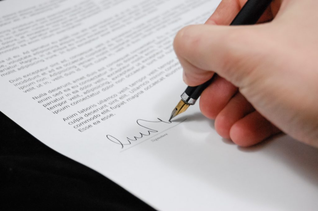 an image of someone signing a trust deed close up