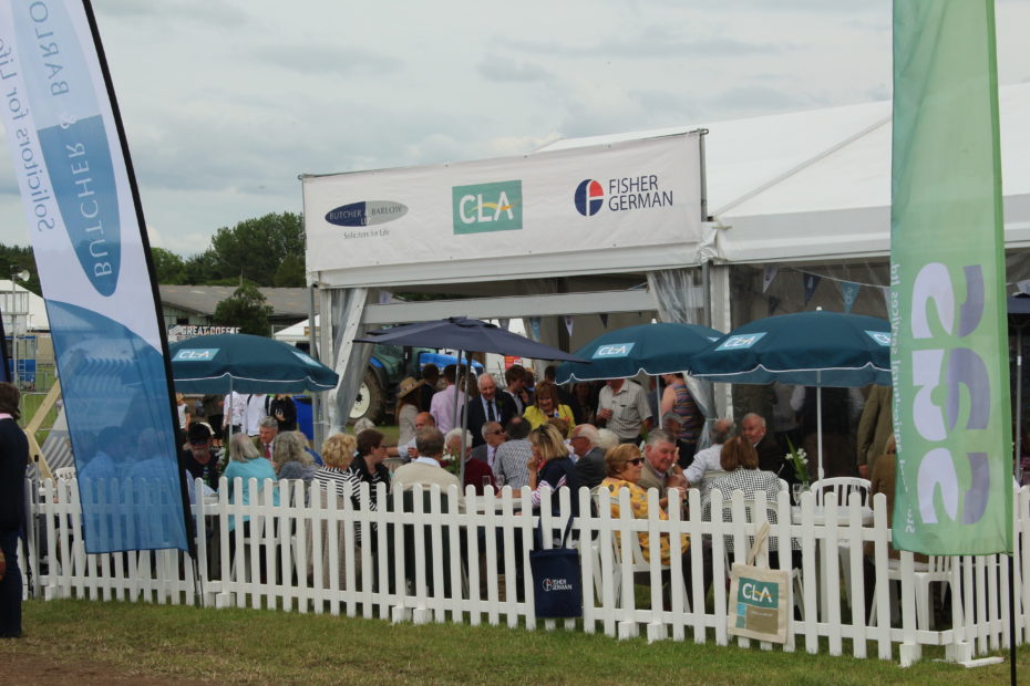 A large crowd sitting under a large marquee